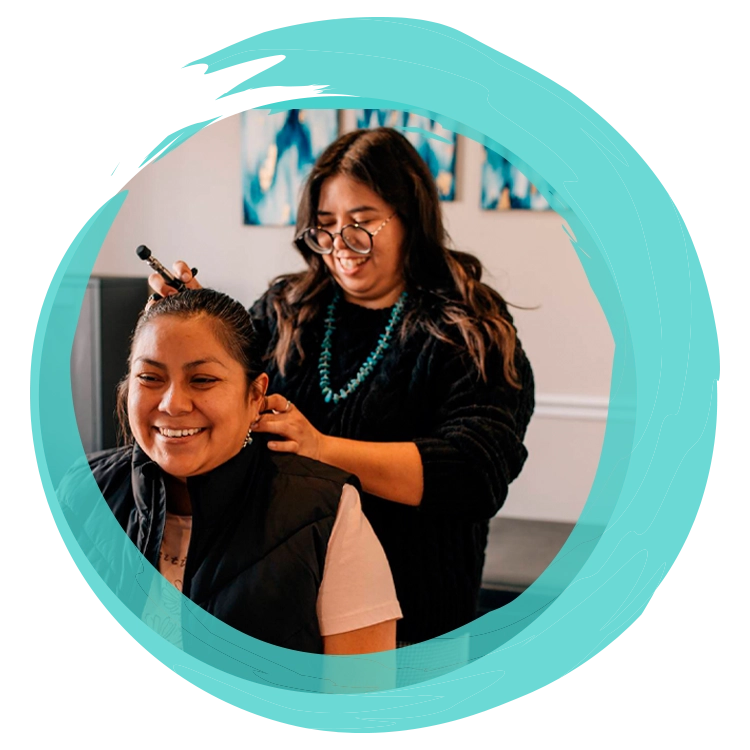 Dr. Lindsay Hall using an adjustment tool on a patient’s upper neck area during a treatment session.